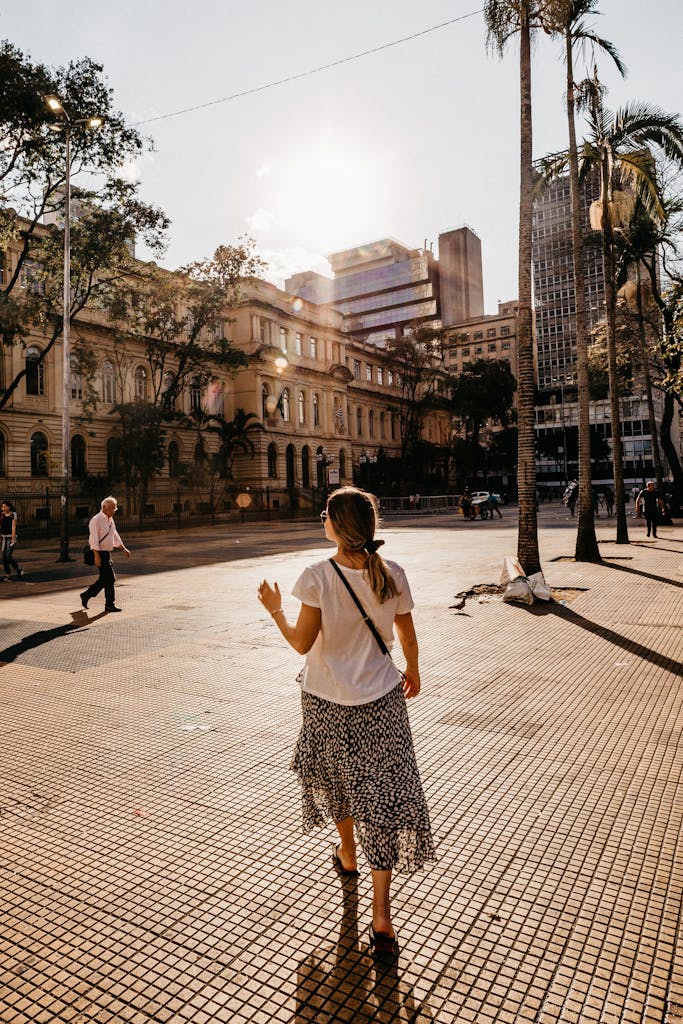 Woman Wearing White Shirt and Gray Skirt While Walking